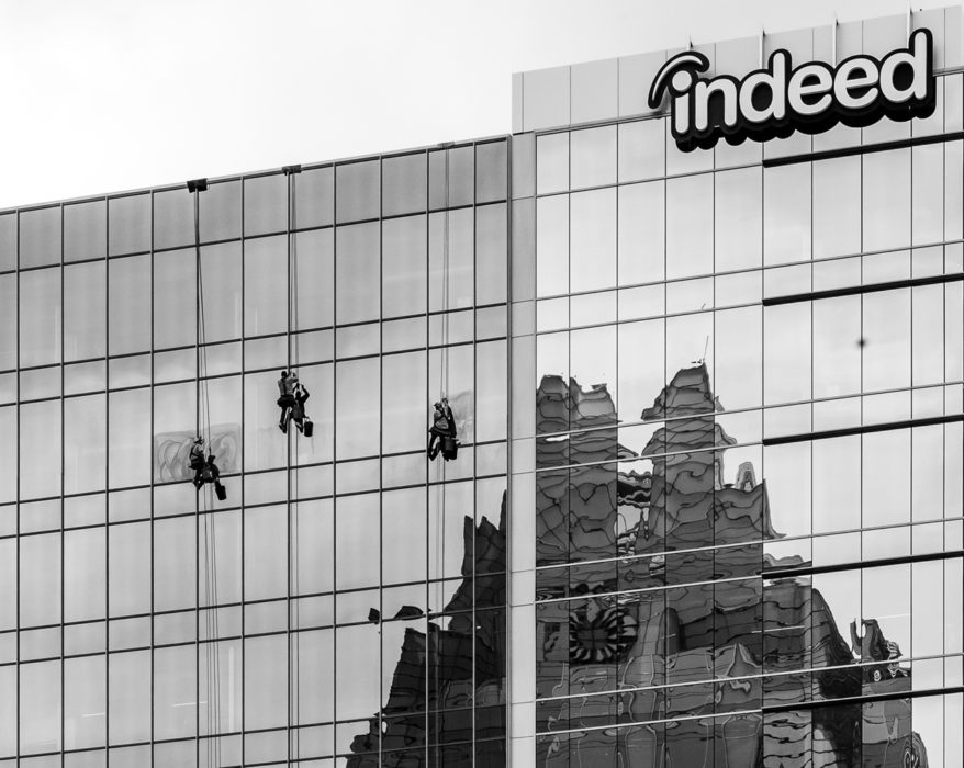 View of the Indeed building downtown and a reflection of the Frost Building