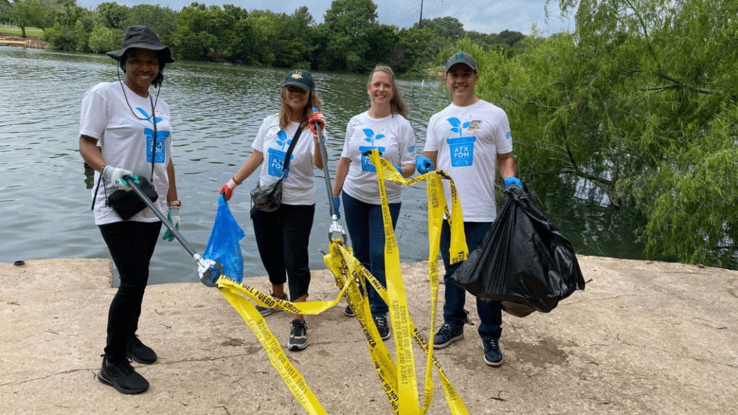 Volunteers from the Downtown Alliance pick up trash where Shoal Creek empties into Lady Bird Lake