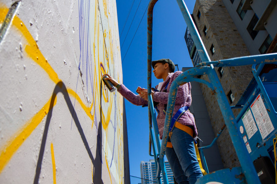 sade lawson painting her mural during writing on the walls 2020 in austin texas