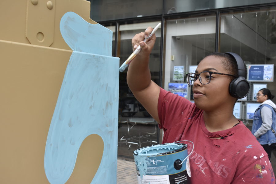 Hailey Gearo painting her ARTBOX sponsored by Den properties and the downtown austin alliance foundation in downtown austin